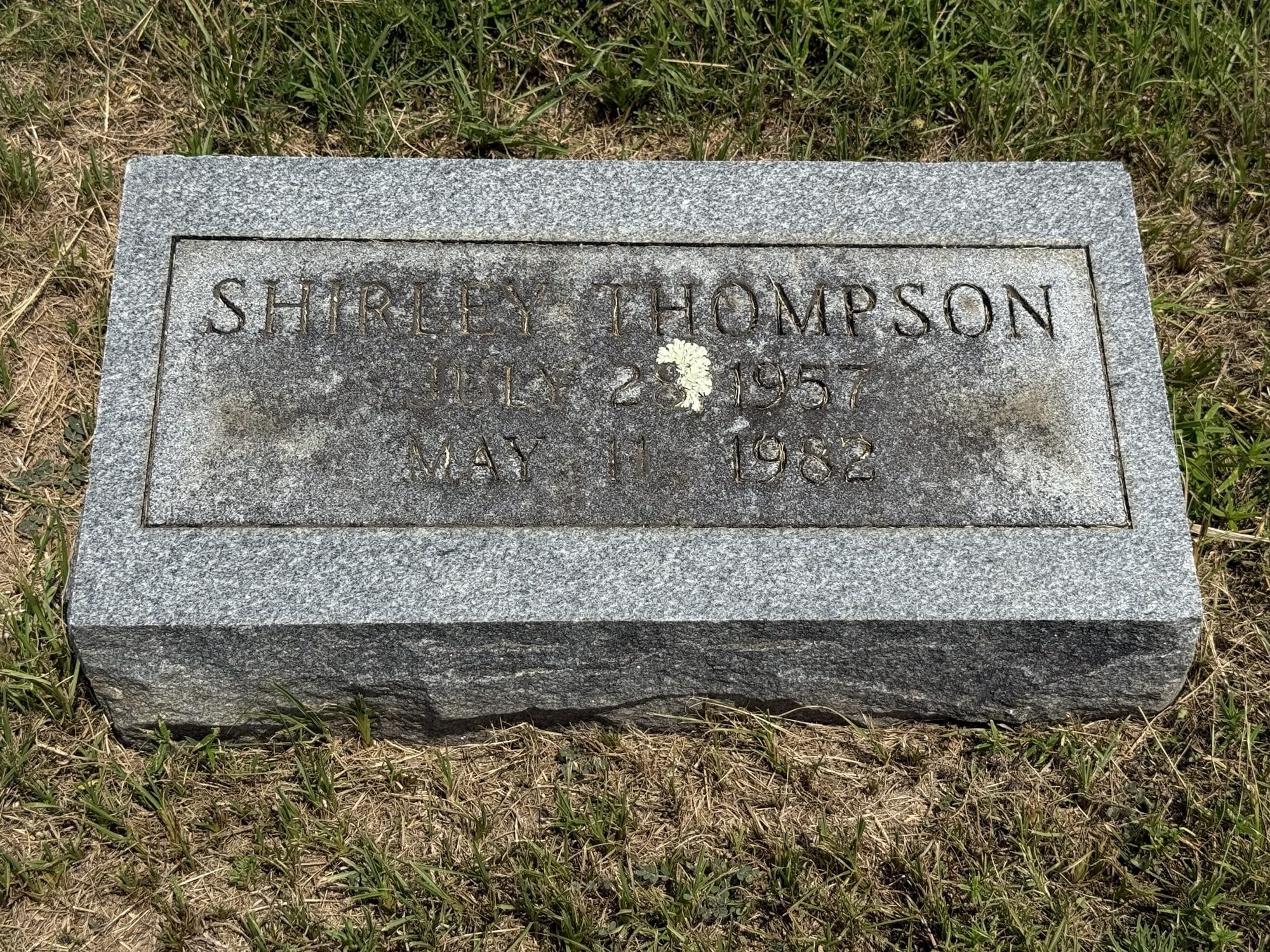 A granite gravestone marking the resting place of Shirley Thompson, with the dates July 28, 1957, and May 1, 1982.